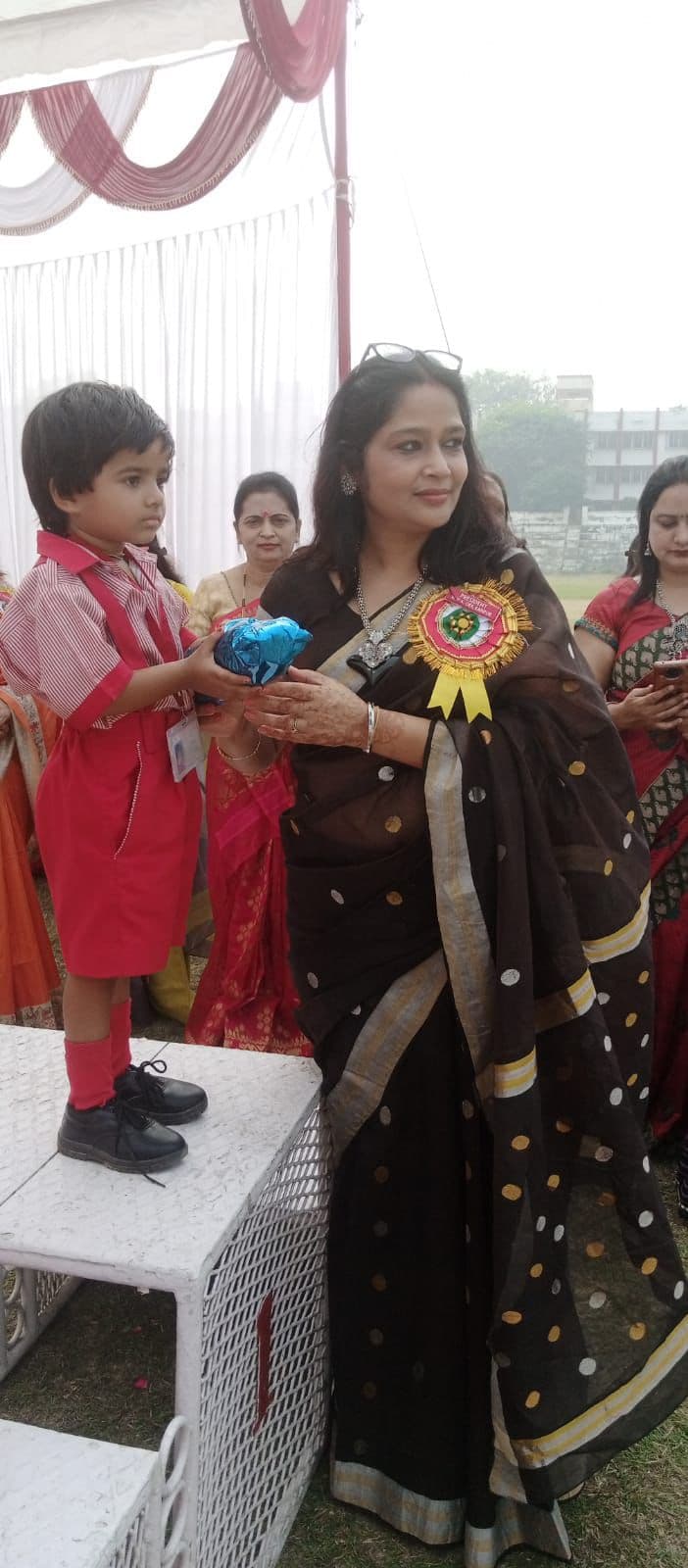 Young student presenting a gift at the Sports Day prize ceremony