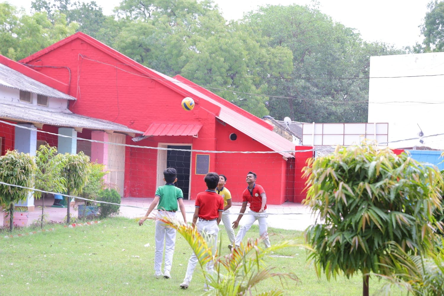 Older students playing volleyball in the courtyard